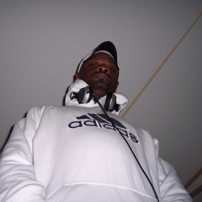 Deejay Gyro in a white sweatshirt looking down at the camera