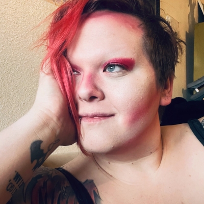 Adrienne holding her face with hand with a tattoo with red hair