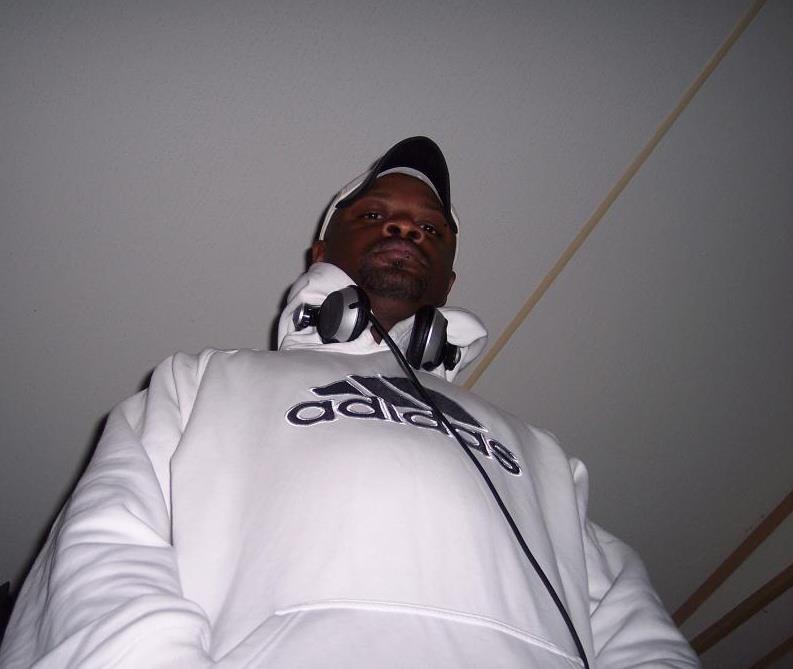 Deejay Gyro in a white sweatshirt looking down at the camera