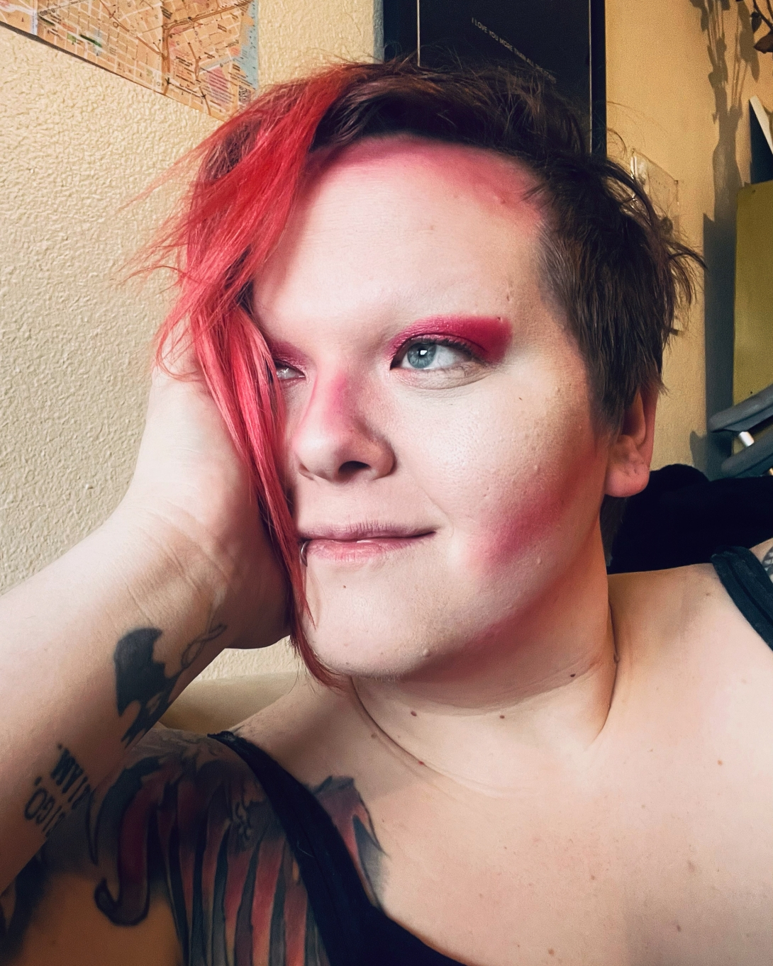 Adrienne holding her face with hand with a tattoo with red hair
